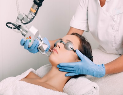 woman wearing protective glasses, getting laser facial treatment. Facial skin rejuvenation