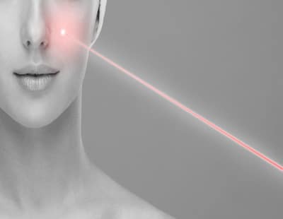 Doctor removing moles using laser ray. Beauty portrait of a young woman. Birthmark removal, plastic surgery, skin lifting and aesthetic medicine concept.