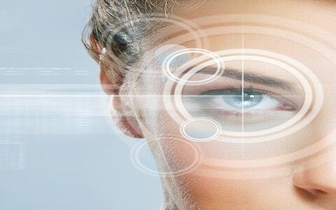 Close-up portrait of young and beautiful woman with the virtual hologram on her eyes (laser medicine and security technology concept)